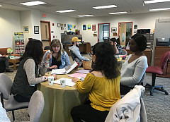 Students sitting around a table with a career counselor at an open house.