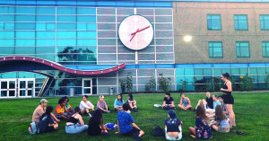 International students gather in a circle on the Great Lawn.