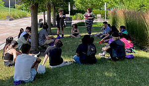Group of students sitting in the grass in a circle