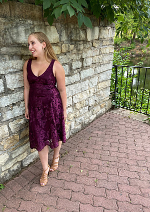 Student standing in front of brick wall
