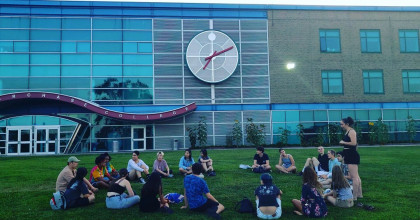 International Students sitting in front of the Student Services building