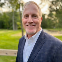 Man with suit jacket standing outside