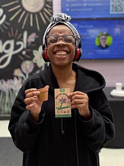 HerbalistDayStudent Student holding herb seed packet and painted pot at Herbalist Day celebration.
