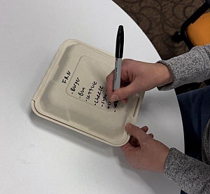 FRN volunteer writing on food box