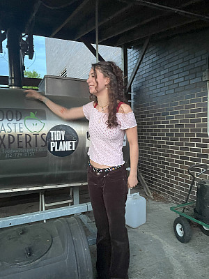 Student Samantha Deturris stands in front of the Rocket Composter