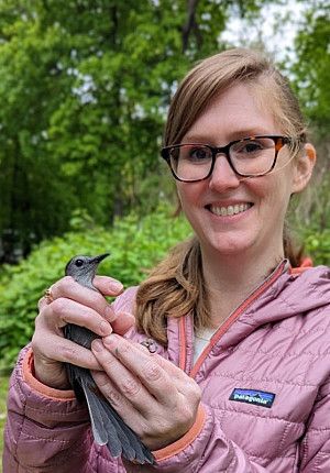 Dr. Jackson is pictured outside holding a bird in both hands.