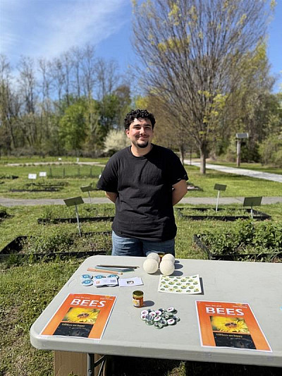 Student hosting bee information table at Arbor Day Celebration. 