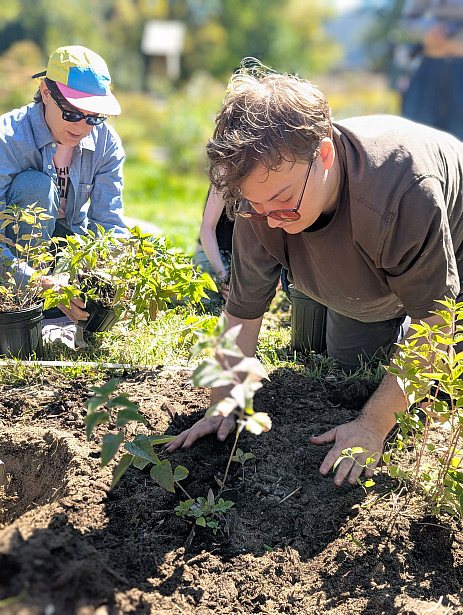 Student planting in Native Plant Garden