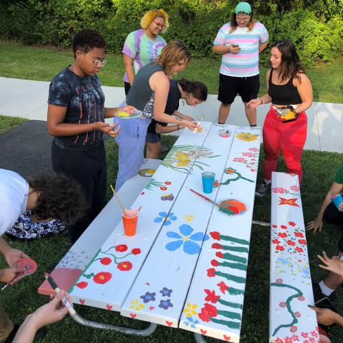 Students painting one of the picnic tables at the Native Plant Garden