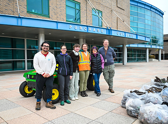 Members of Sustainability team posing next to trash pile from Campus Clean Up. 