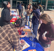 Purchase students around a table near the clock tower on SUNY Purchase campus