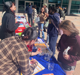 Purchase students around a table near the clock tower on SUNY Purchase campus