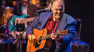 Rob Mathes playing guitar on stage