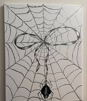 A black and white drawing of a spider web with a ribbon shape formed in the web's center. A realistic spider hangs from the middle, attach