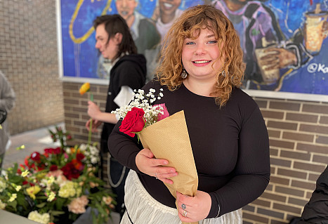 Harley smiles and holds a flower bouquet