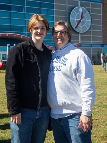 Student and family posing near Student Services Building