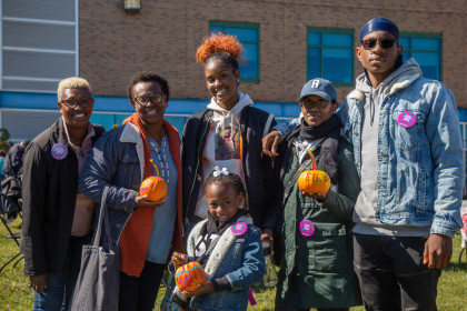 Student posing with family near Student Services Building