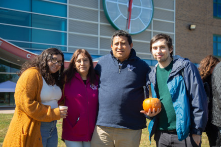 Student and family posing near Student Services Building