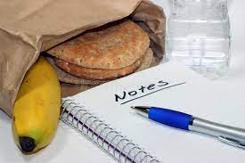 Brown bag lunch with bottle of water, a notepad with the word notes written on it, and a blue p...