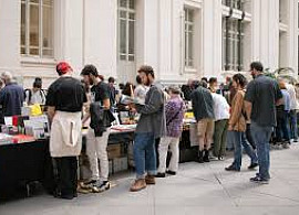 People standing at tables at a book fair
