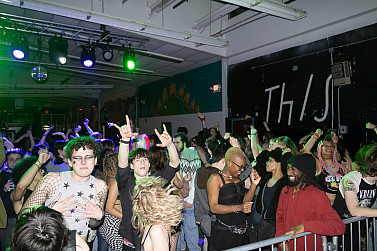 A crowd dances under colored lights.