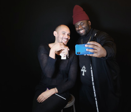 Professor Shaka McGlotten and MFA student Jaleel Campbell are taking selfies during the opening of Palace of the Self Exhibition, Fall 2018