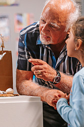 Older gentleman and young child examining a sculpture on a pedastal