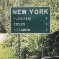 A green road sign with large white text reading NEW YORK at the top, and below, three lines: PURCHASED ?, STOLEN ?, and RECLAIMED ?