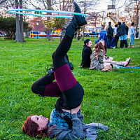 Culture Shock - photo of student laying on her back in the grass twirling a hula hoop with her foot