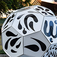 A large soccer ball shaped sculpture, white with black squiggly designs