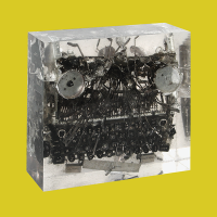 Luis Perelman, Typewriter Block 1, 2004, Found materials (typewriter) embedded in clear resin, 12 x 12 x 4 inches.
