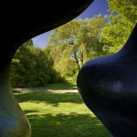 A view of the Purchase College campus through the curves of the Large Two Forms statue by Henry Moore