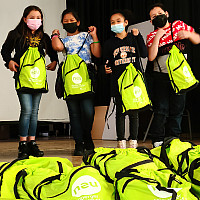 Children at the Enrico Fermi School in Yonkers receive NEU Kids Pack backpacks filled with art supplies from the Neuberger Museum of Art