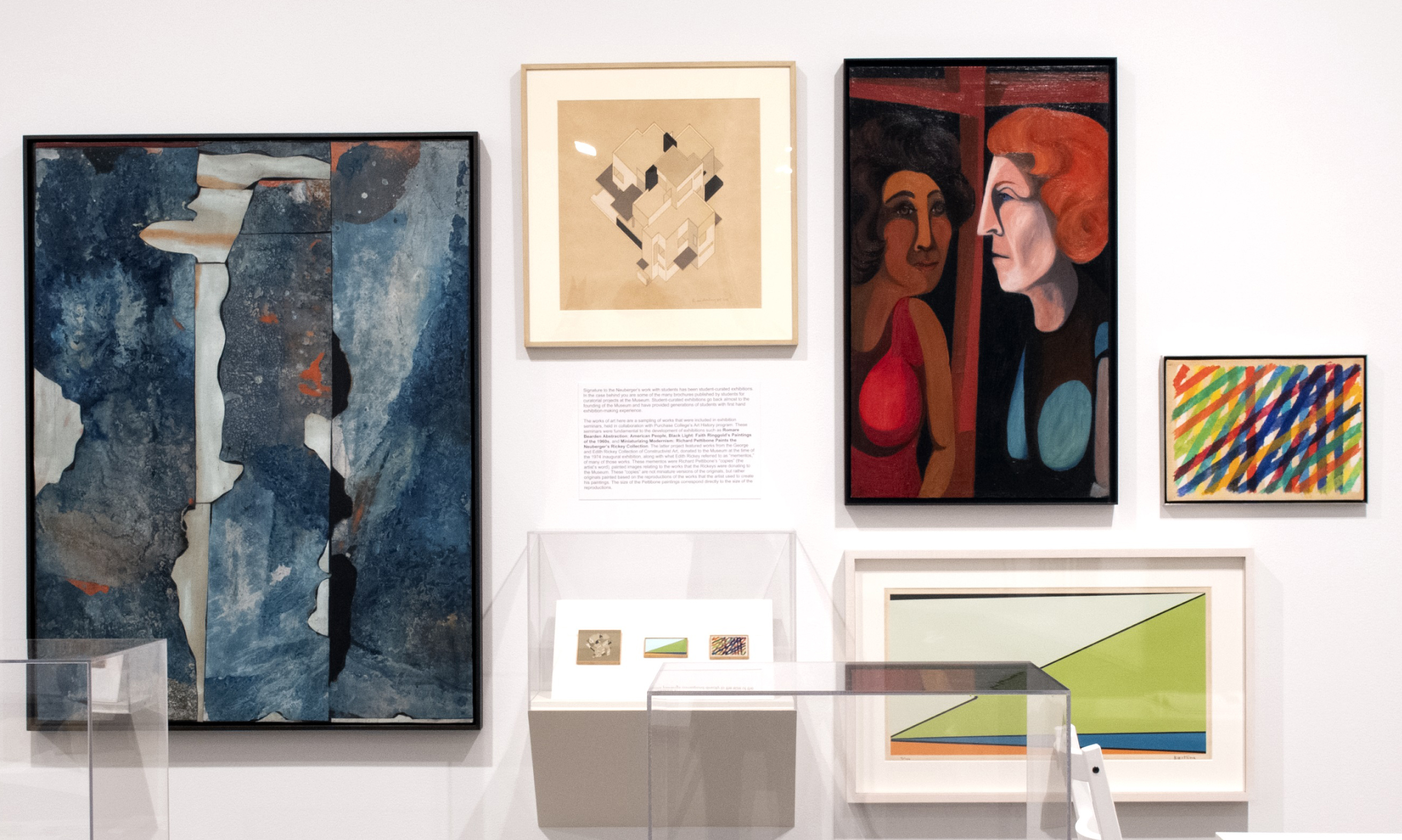 A collection of paintings on a gallery wall in the Neuberger Museum of Art