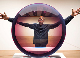 Artist Fred Eversley with 'Untitled (Parabolic Lens) 1971', made of cast polyster resin, during a press preview for the exhibition: Space...