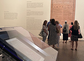 People in an art gallery reading wall text