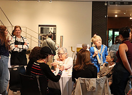 A crowd of people in a museum gallery.
