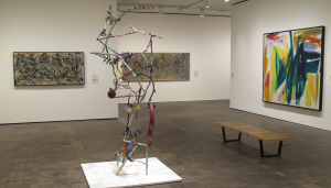 Neuberger Museum of Art backstory blog logo with an image of a gallery in the Then and Now exhibition featuring an artwork by Jackson Pollock