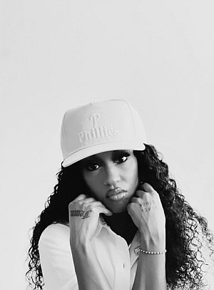 Black and white photograph of a woman with a white hat and curly hair