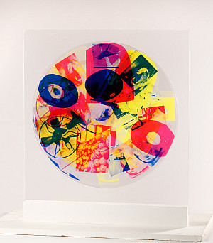 A colorfully printed round pexiglass wheel on a stand