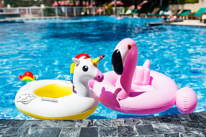 On vacation!  Unicorn and flamingo floats on a pool.