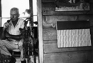    Forrest Bess with his painting Untitled (11A), in his home/studio, Chinquapin Bayou, near East Matagorda Bay, Texas, 1958. The Menil A...