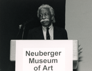 Gordon Parks at a podium with the words Neuberger Museum of Art