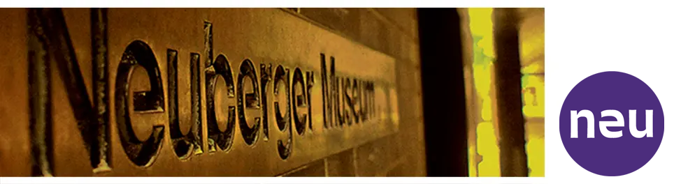 A photo of a bronze sign that says Neuberger Museum, shot at a sharp angle