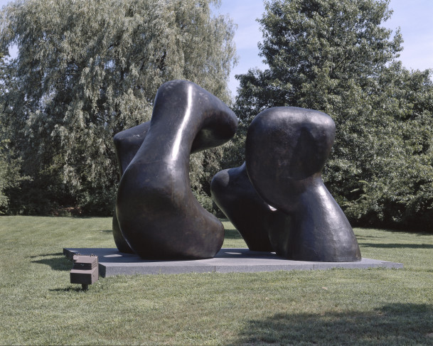 Outdoor sculpture. A pair of large bronze forms next to one another with space to walk between them. Both have openings in the center. Th...