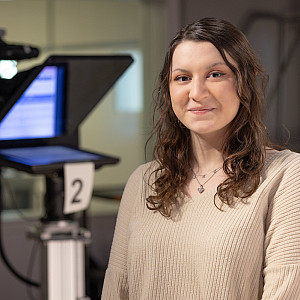 Smiling student with computer in background.