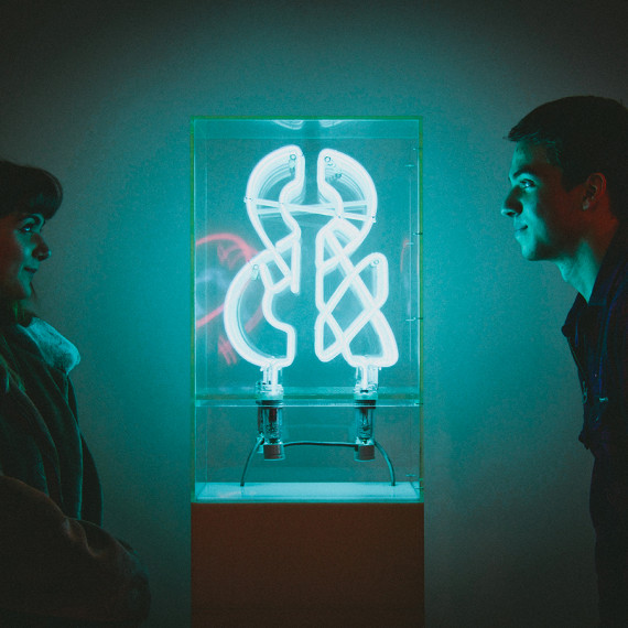 Students observe a neon sculpture on view at the Neuberger Museum of Art.