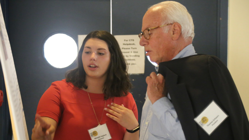 President Schwarz speaks with a student at the annual Natural and Social Sciences Symposium
