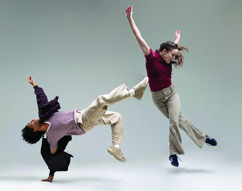 Two dancers with limbs extended in difference directions