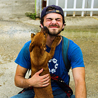 Patrick Moore '21 with a dog as he volunteers with the SUNY Stands with Puerto Rico initiative